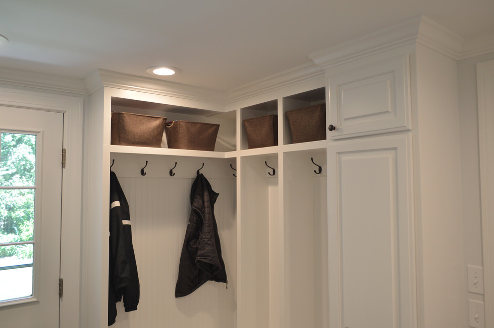 This is an example of a small traditional mudroom in Providence with white walls, porcelain floors and grey floor.