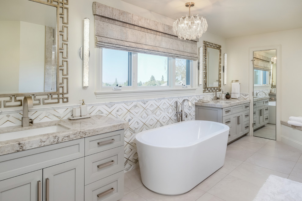 Inspiration for a mediterranean master bathroom in San Francisco with shaker cabinets, beige cabinets, a freestanding tub, multi-coloured tile, beige walls, an undermount sink, beige floor, beige benchtops and granite benchtops.