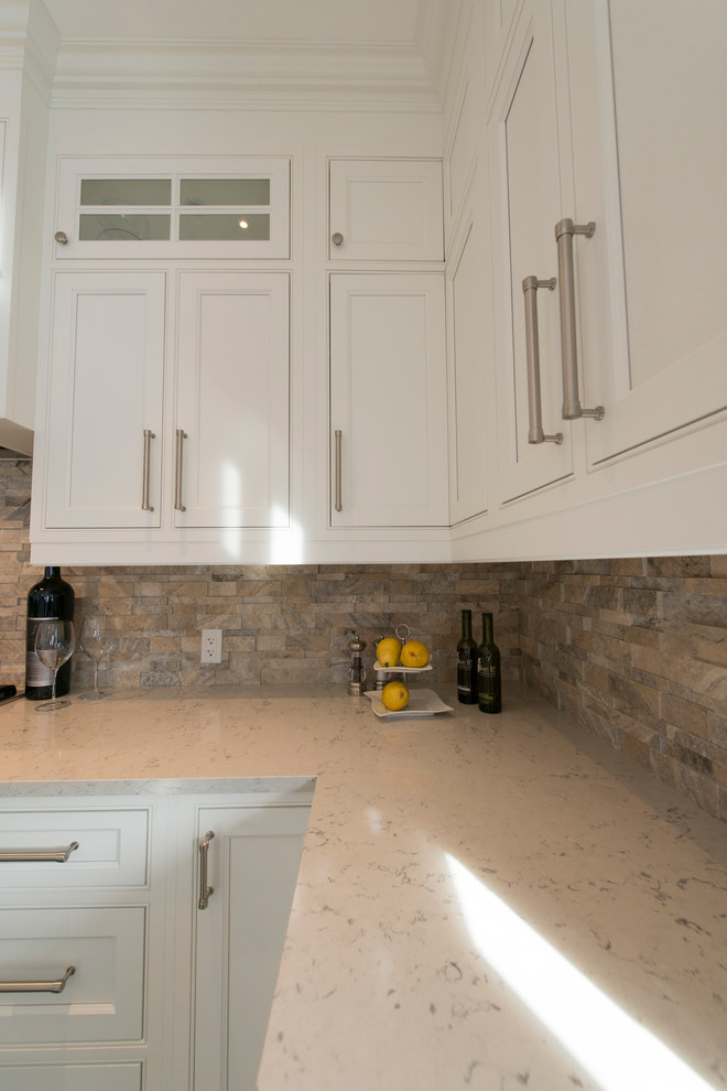 Example of a transitional porcelain tile and gray floor eat-in kitchen design in Toronto with an undermount sink, beaded inset cabinets, white cabinets, quartzite countertops, brick backsplash, stainless steel appliances, an island and white countertops
