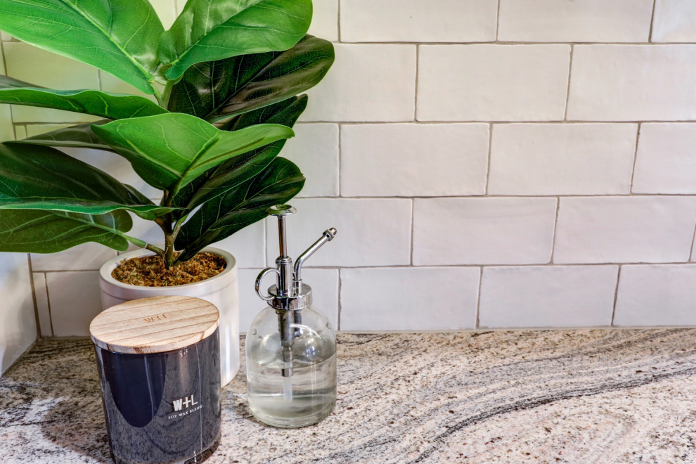 Example of a mid-sized transitional l-shaped vinyl floor and gray floor kitchen pantry design with a farmhouse sink, recessed-panel cabinets, blue cabinets, granite countertops, white backsplash, subway tile backsplash, stainless steel appliances, no island and gray countertops