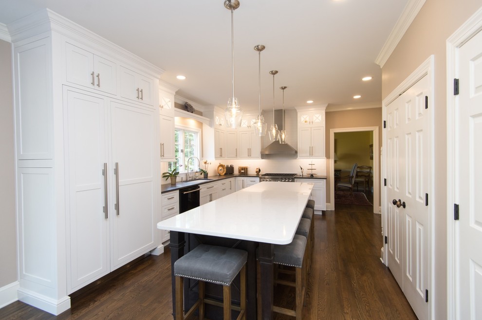 Eat-in kitchen - large transitional l-shaped dark wood floor and brown floor eat-in kitchen idea with an undermount sink, paneled appliances, beaded inset cabinets, white cabinets, white backsplash, subway tile backsplash, an island and black countertops
