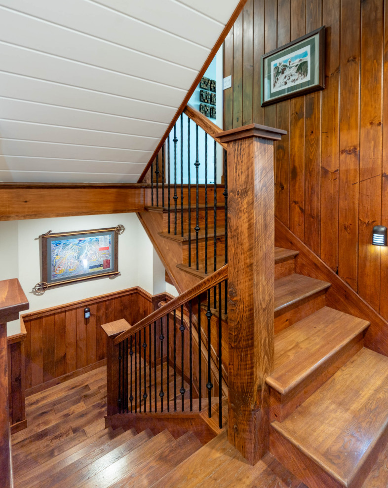 Стильный дизайн: деревянная лестница в стиле рустика с деревянными ступенями, металлическими перилами и стенами из вагонки - последний тренд