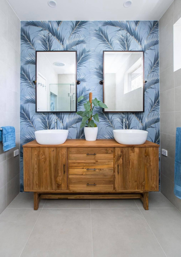 Medium sized retro bathroom in Melbourne with freestanding cabinets, light wood cabinets, a corner shower, a one-piece toilet, blue tiles, porcelain tiles, blue walls, porcelain flooring, wooden worktops, beige floors, a hinged door, a wall niche, double sinks and a freestanding vanity unit.