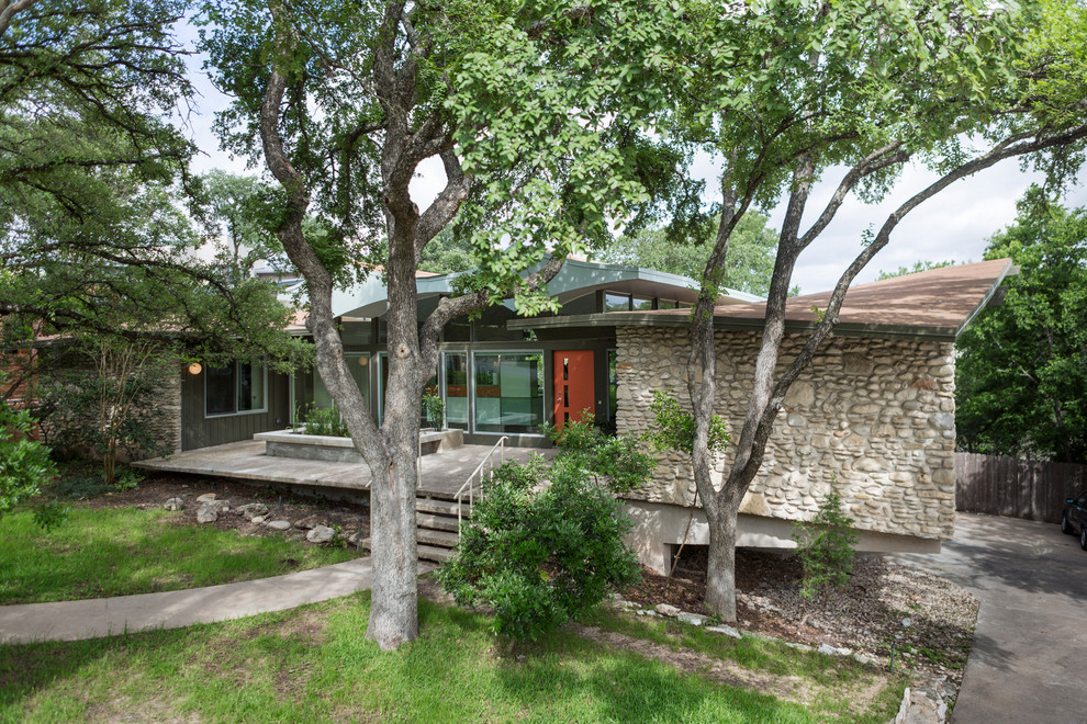 Mid-sized midcentury one-storey exterior in Austin with mixed siding.