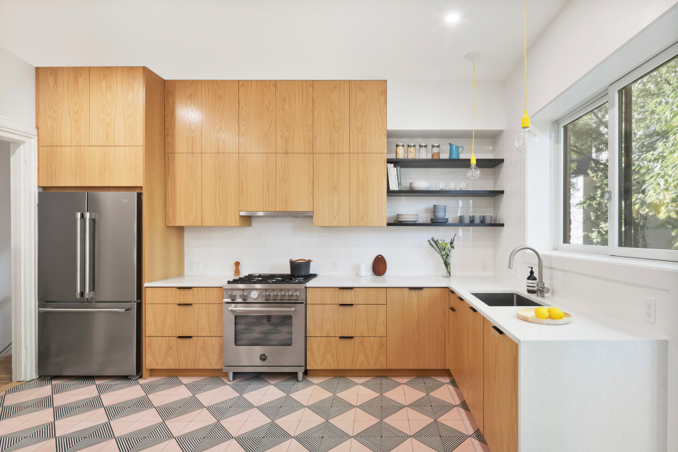 Inspiration for a contemporary l-shaped kitchen in New York with an undermount sink, flat-panel cabinets, quartz benchtops, white splashback, subway tile splashback, stainless steel appliances, cement tiles, white benchtop, medium wood cabinets, no island and multi-coloured floor.