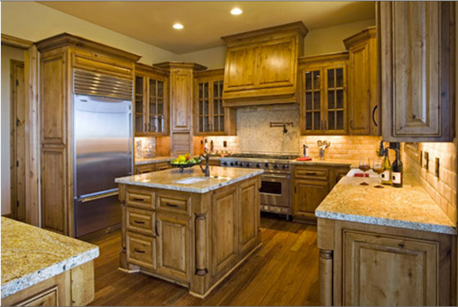 Eat-in kitchen - mid-sized rustic u-shaped medium tone wood floor eat-in kitchen idea with an undermount sink, shaker cabinets, medium tone wood cabinets, granite countertops, beige backsplash, ceramic backsplash, stainless steel appliances and an island