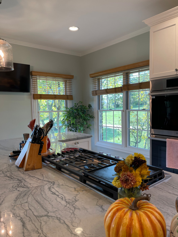 Inspiration for a large transitional light wood floor and brown floor eat-in kitchen remodel with an undermount sink, shaker cabinets, white cabinets, quartzite countertops, green backsplash, marble backsplash, stainless steel appliances, an island and gray countertops