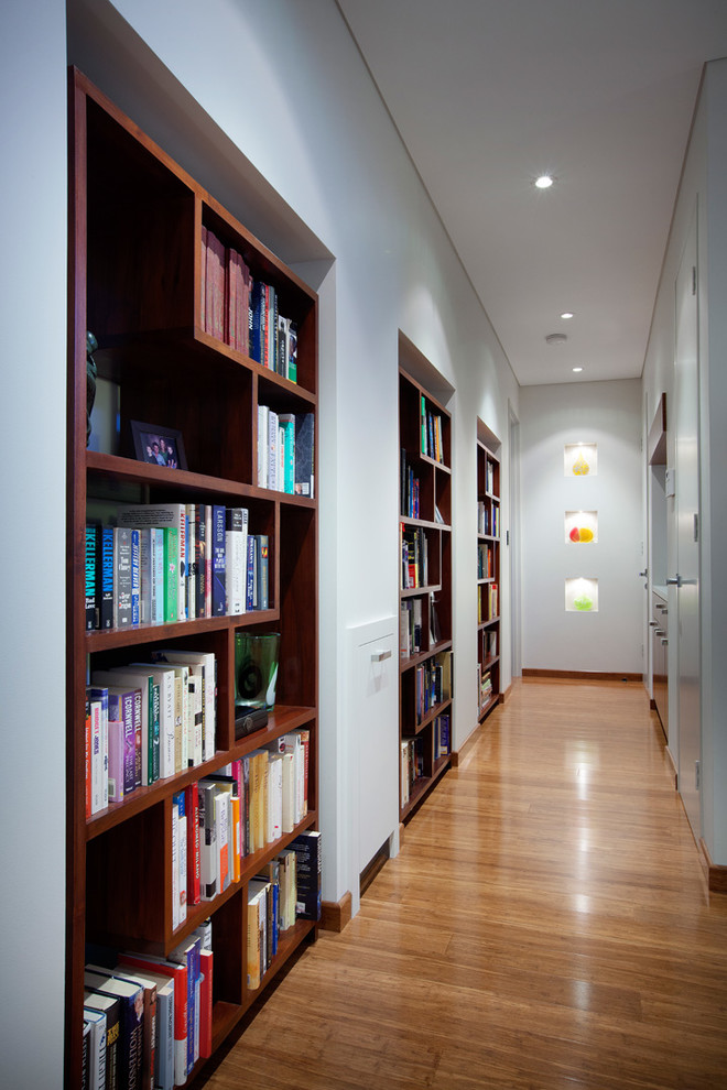 Photo of a contemporary hallway in Other with white walls and medium hardwood floors.