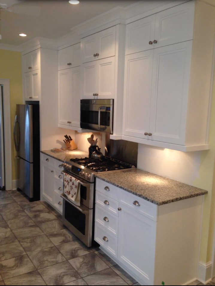 Eat-in kitchen - mid-sized transitional single-wall slate floor eat-in kitchen idea with recessed-panel cabinets, white cabinets, granite countertops, a farmhouse sink, beige backsplash, matchstick tile backsplash and stainless steel appliances