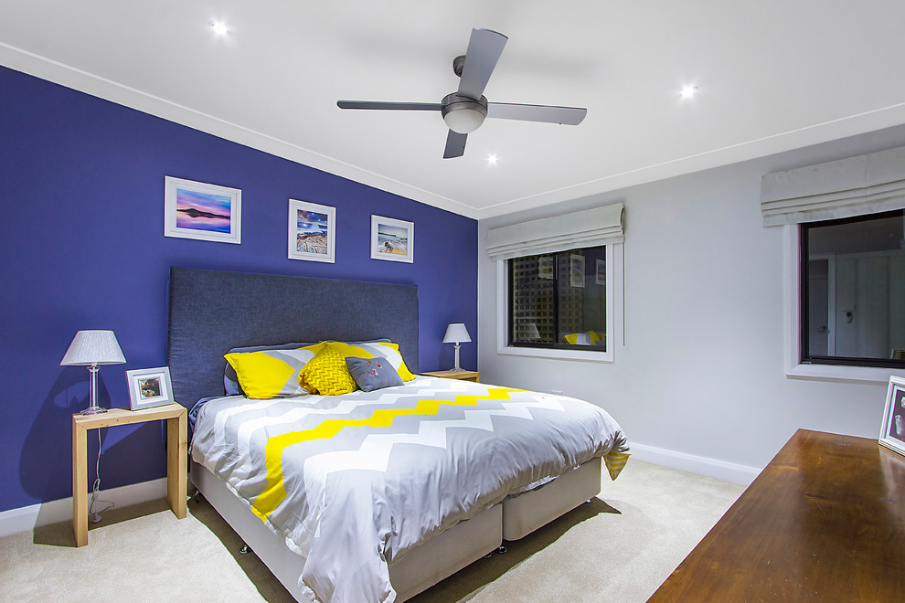 Photo of a mid-sized master bedroom in Sydney with blue walls and carpet.