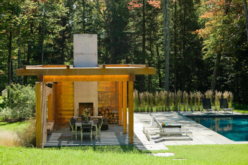 Inspiration for a large contemporary backyard rectangular lap pool in Burlington with natural stone pavers and a pool house.