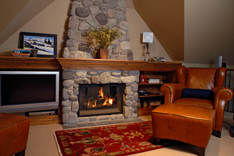 Photo of a mid-sized country enclosed family room in Vancouver with brown walls, carpet, a standard fireplace, a stone fireplace surround and a built-in media wall.
