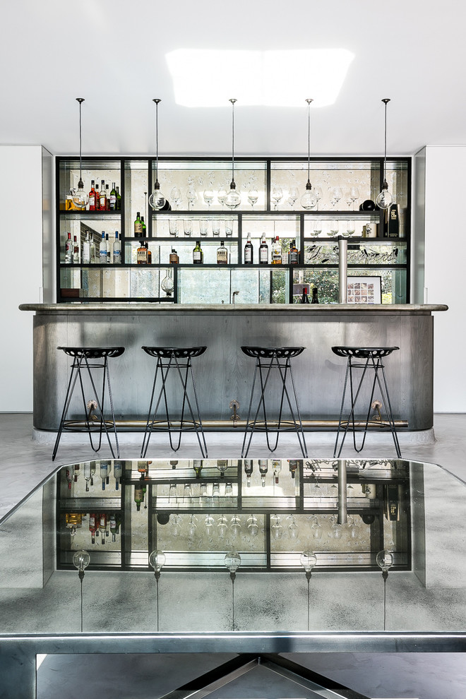 Inspiration for a mid-sized contemporary galley bar cart in London with open cabinets, black cabinets, stainless steel benchtops, concrete floors and grey floor.