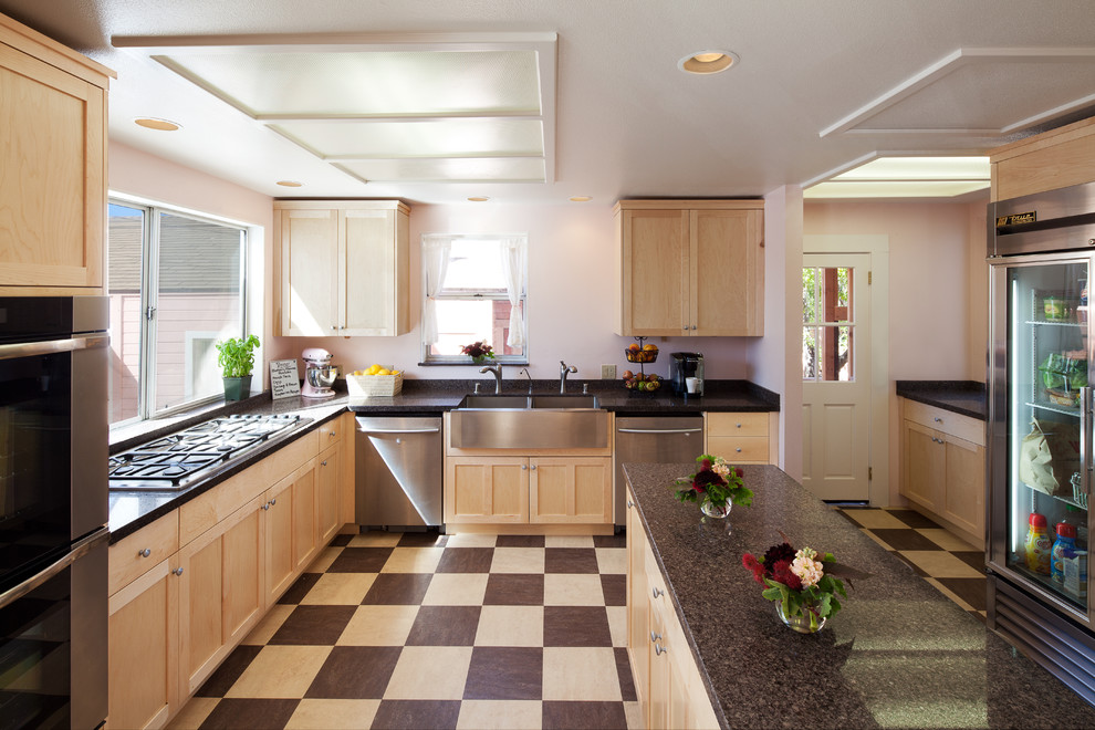 Inspiration for a traditional u-shaped kitchen in San Luis Obispo with a double-bowl sink, shaker cabinets, light wood cabinets and stainless steel appliances.