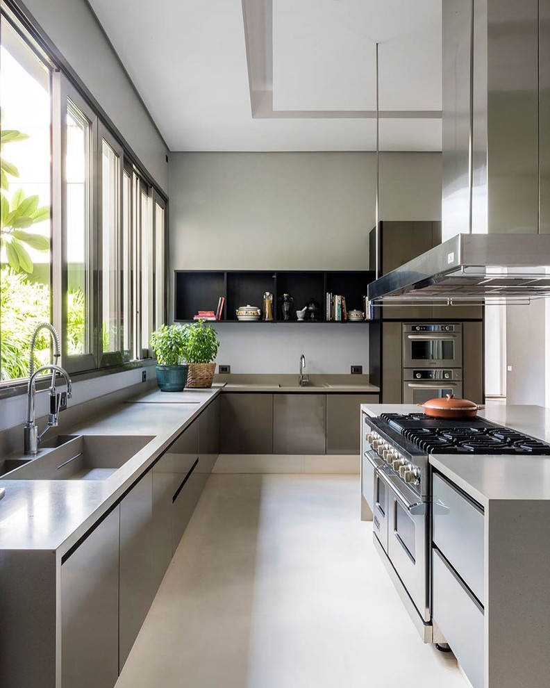 Inspiration for a large contemporary u-shaped eat-in kitchen in San Francisco with a drop-in sink, flat-panel cabinets, grey cabinets, quartz benchtops, white splashback, stone slab splashback, stainless steel appliances, concrete floors, with island, white floor and grey benchtop.