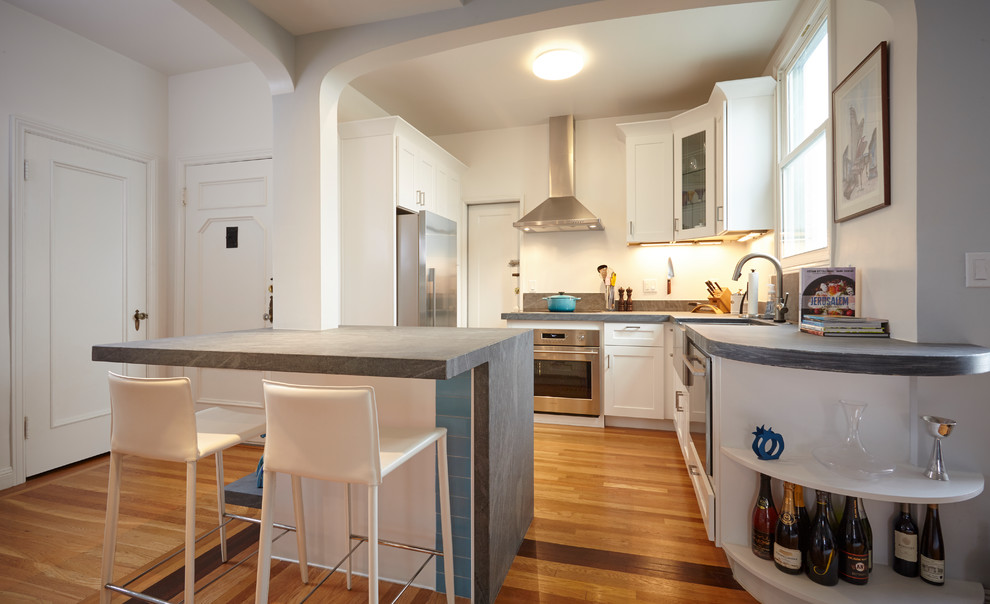 Design ideas for a small contemporary l-shaped eat-in kitchen in San Francisco with a farmhouse sink, shaker cabinets, white cabinets, marble benchtops, grey splashback, marble splashback, stainless steel appliances, medium hardwood floors and with island.