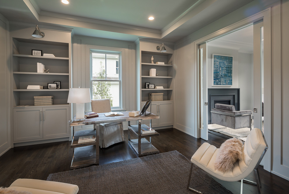 This is an example of a transitional study room in New York with grey walls, dark hardwood floors and a freestanding desk.