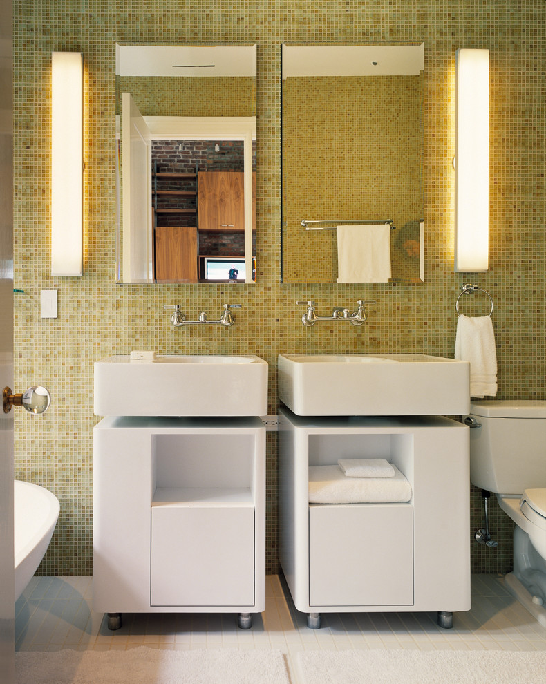 This is an example of a modern bathroom in New York with a wall-mount sink, white cabinets, yellow tile and mosaic tile.