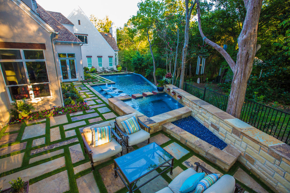 Inspiration for an expansive contemporary backyard custom-shaped lap pool in Dallas with a hot tub and natural stone pavers.