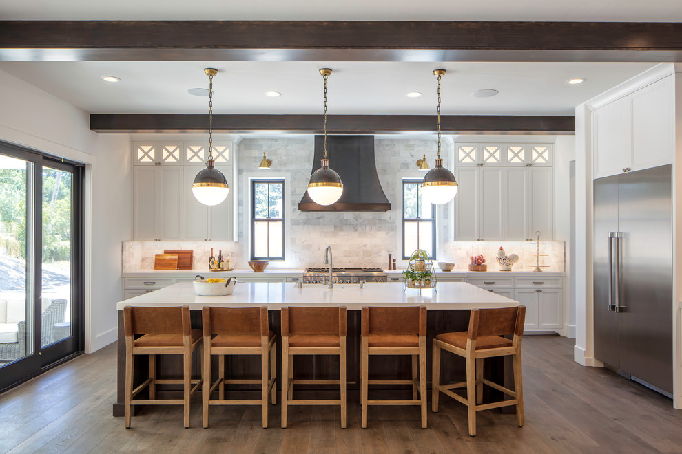 Inspiration for a large country l-shaped medium tone wood floor and brown floor open concept kitchen remodel in San Francisco with a farmhouse sink, shaker cabinets, white cabinets, quartz countertops, gray backsplash, marble backsplash, stainless steel appliances, an island and white countertops