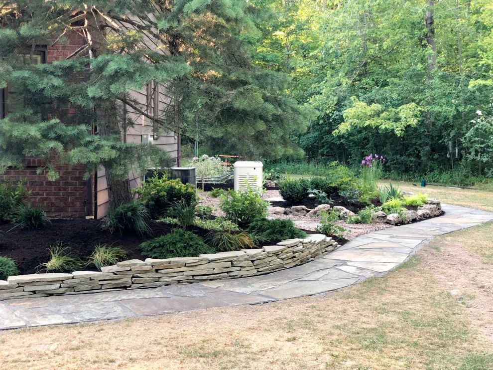 This is an example of a large traditional front yard partial sun driveway for summer in New York with with pond and concrete pavers.