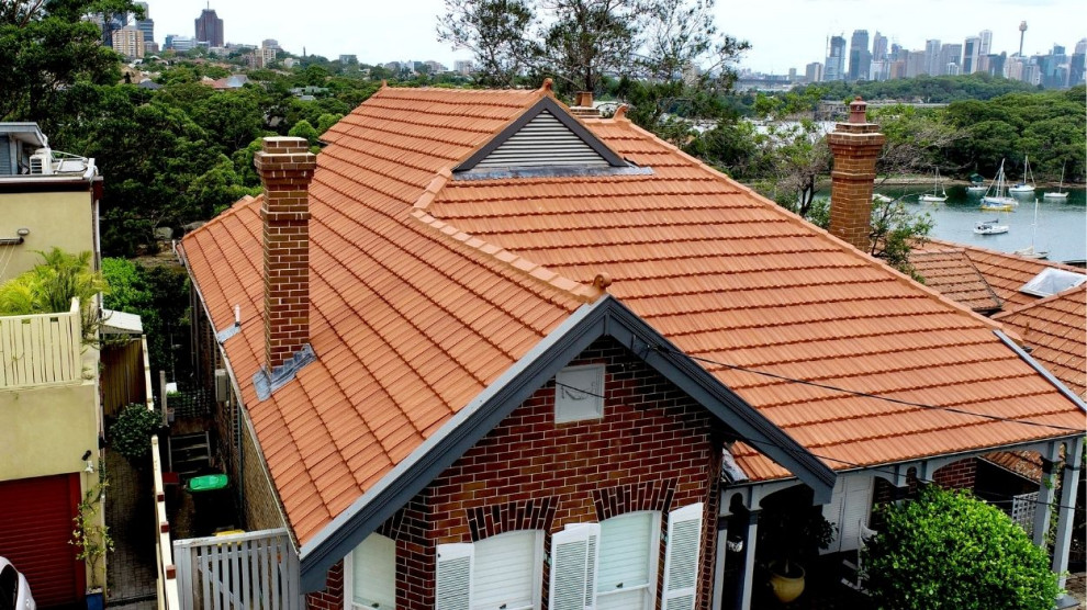 Ejemplo de fachada roja clásica con tejado de teja de barro