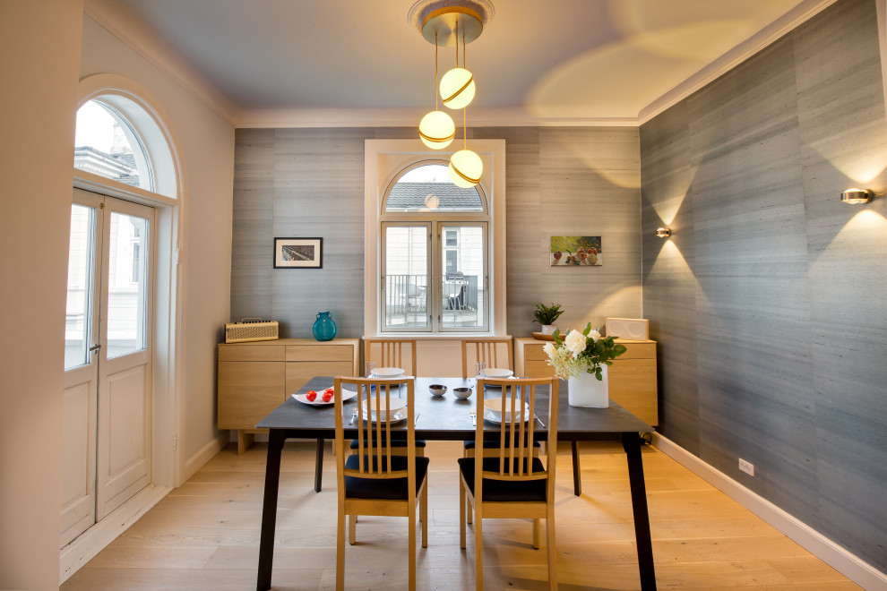 Ispirazione per una grande sala da pranzo aperta verso il soggiorno scandinava con pareti con effetto metallico, parquet chiaro e carta da parati