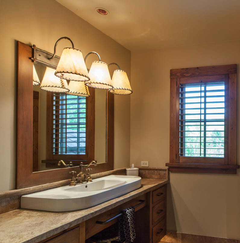 This is an example of an expansive country master bathroom in Other with a pedestal sink, flat-panel cabinets, distressed cabinets, wood benchtops, beige tile, stone slab, beige walls and slate floors.