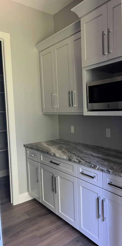 Kitchen - large transitional kitchen idea with an undermount sink, shaker cabinets, gray cabinets, quartz countertops, white backsplash, stainless steel appliances, two islands and white countertops