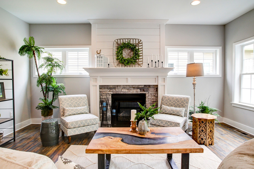 Inspiration for a country open concept living room with grey walls, vinyl floors, a standard fireplace, a stone fireplace surround and brown floor.