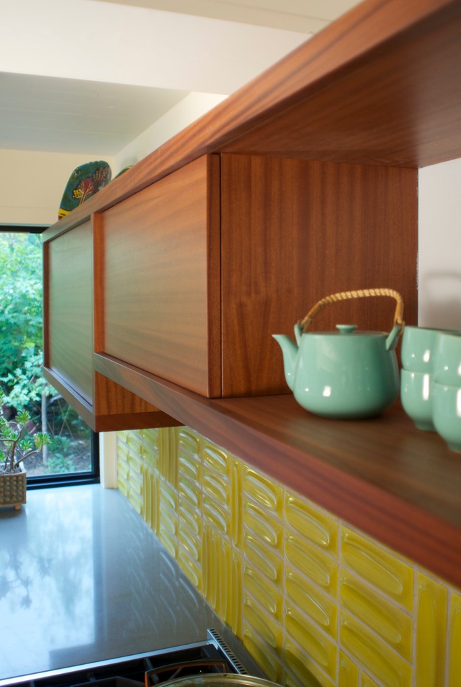 Design ideas for a mid-sized midcentury u-shaped kitchen in Denver with a double-bowl sink, flat-panel cabinets, medium wood cabinets, quartz benchtops, yellow splashback, stainless steel appliances and light hardwood floors.