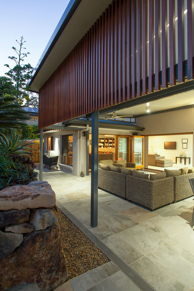 Inspiration for a mid-sized contemporary backyard patio in Brisbane with tile and a roof extension.