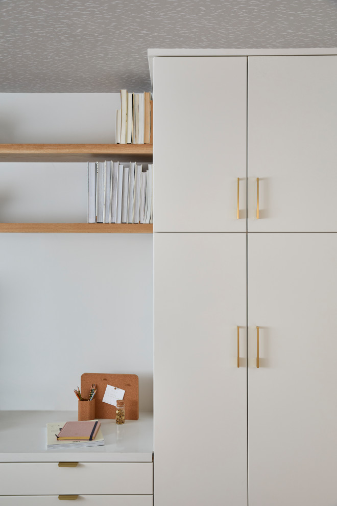 Imagen de despacho escandinavo pequeño con paredes blancas, suelo de madera clara, escritorio empotrado, suelo marrón y papel pintado