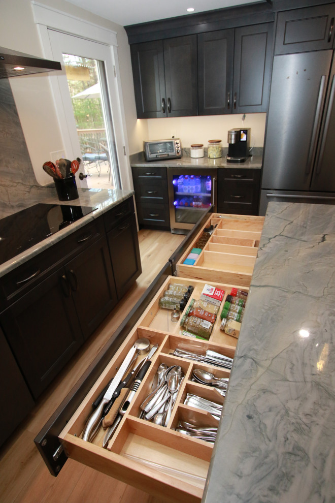 Eat-in kitchen - mid-sized transitional u-shaped laminate floor and brown floor eat-in kitchen idea in Boston with an undermount sink, shaker cabinets, brown cabinets, quartz countertops, black appliances, an island and multicolored countertops