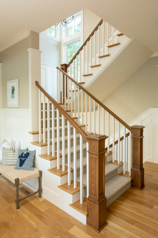 Inspiration for a nautical carpeted staircase in Minneapolis with wood risers and wainscoting.