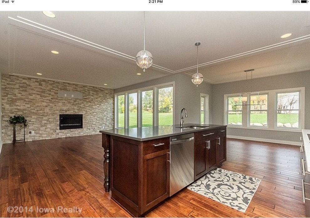 Mid-sized transitional galley medium tone wood floor and multicolored floor open concept kitchen photo with a double-bowl sink, shaker cabinets, dark wood cabinets, quartz countertops, gray backsplash, subway tile backsplash, stainless steel appliances and an island