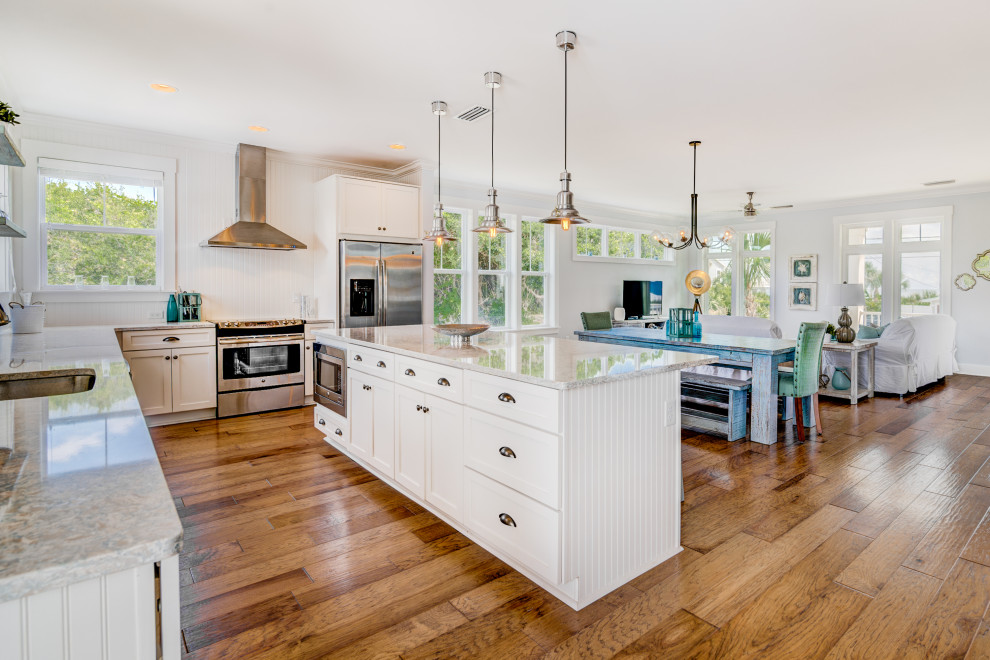 Example of a beach style l-shaped kitchen design in Jacksonville with an undermount sink, shaker cabinets and white cabinets