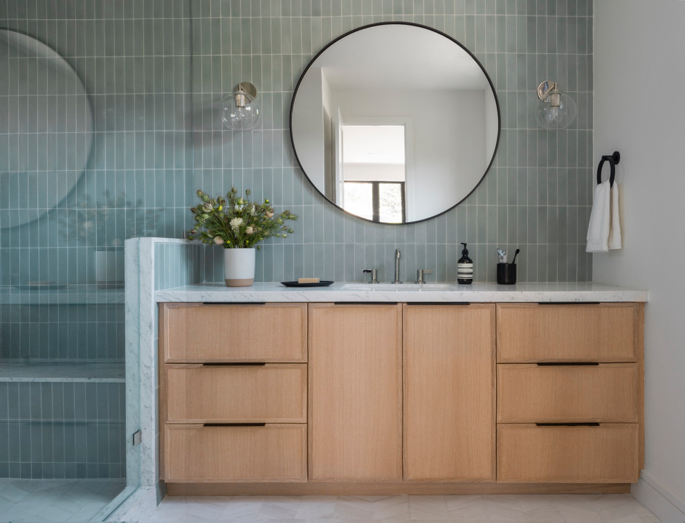This is an example of a mid-sized transitional wet room bathroom in San Francisco with shaker cabinets, light wood cabinets, green tile, ceramic tile, white walls, marble floors, an undermount sink, marble benchtops, white floor, a hinged shower door, white benchtops, a shower seat and a built-in vanity.