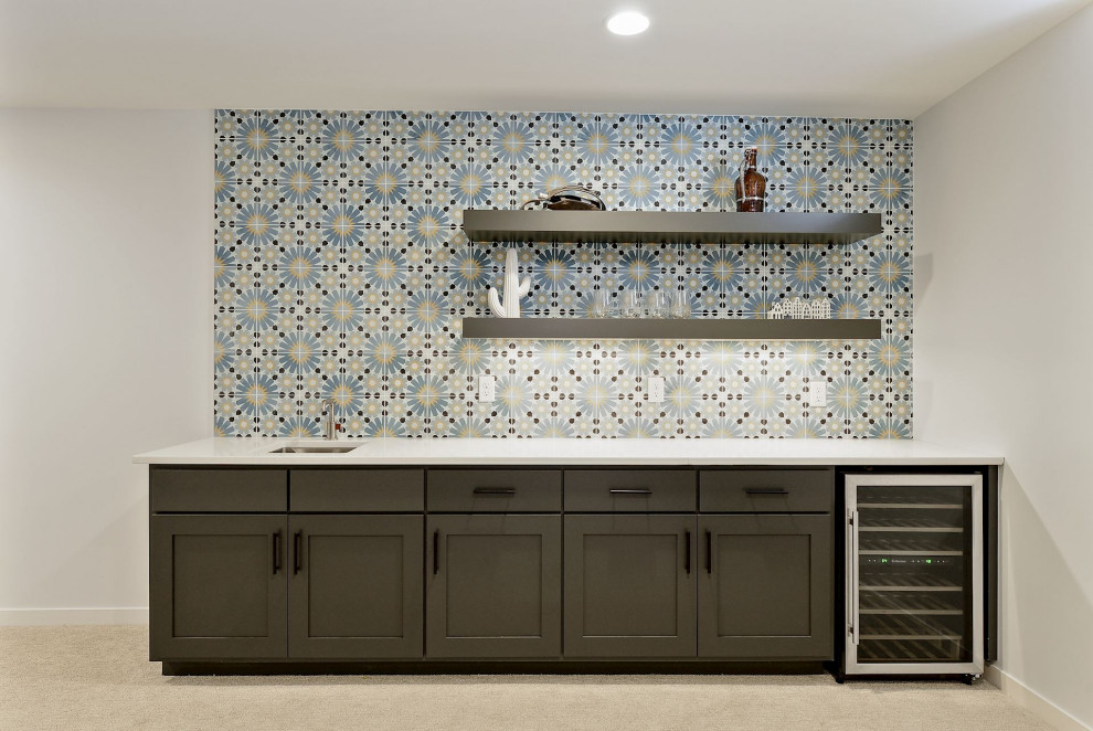 This is an example of an eclectic single-wall wet bar in Minneapolis with an undermount sink, quartzite benchtops, multi-coloured splashback, cement tile splashback, carpet and white benchtop.