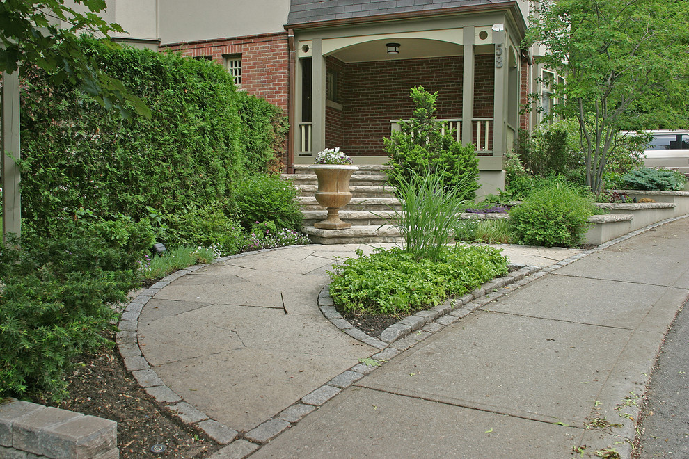 Small transitional backyard partial sun garden in Toronto with a garden path and natural stone pavers for summer.