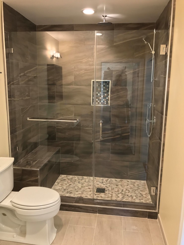 This is an example of a large modern master bathroom in Los Angeles with open cabinets, dark wood cabinets, a double shower, a two-piece toilet, gray tile, ceramic tile, yellow walls, porcelain floors, a wall-mount sink, solid surface benchtops, a hinged shower door, beige floor and white benchtops.
