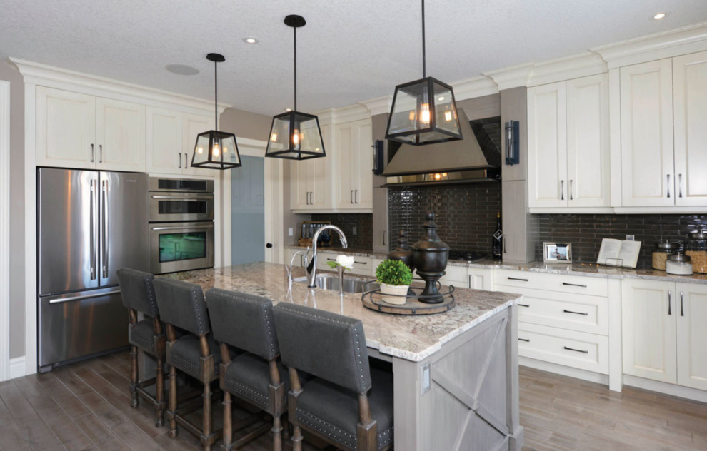 Inspiration for a large transitional l-shaped medium tone wood floor and brown floor eat-in kitchen remodel in Toronto with an undermount sink, recessed-panel cabinets, white cabinets, stainless steel appliances, an island, granite countertops, black backsplash and subway tile backsplash