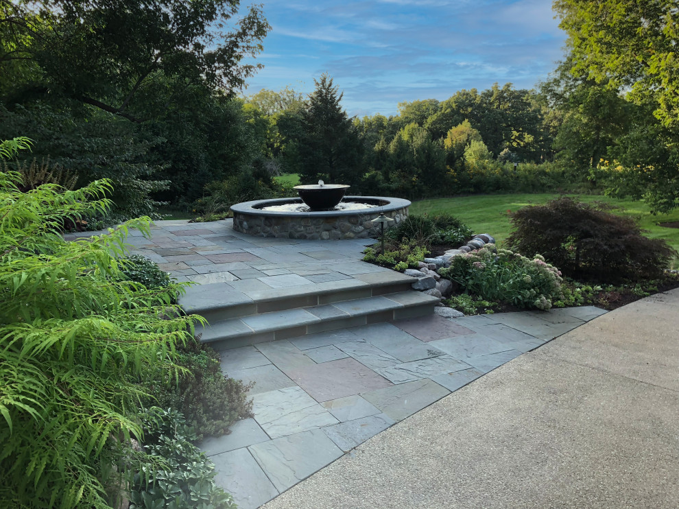 Photo of a mid-sized arts and crafts front yard full sun garden for summer in Chicago with a water feature and natural stone pavers.
