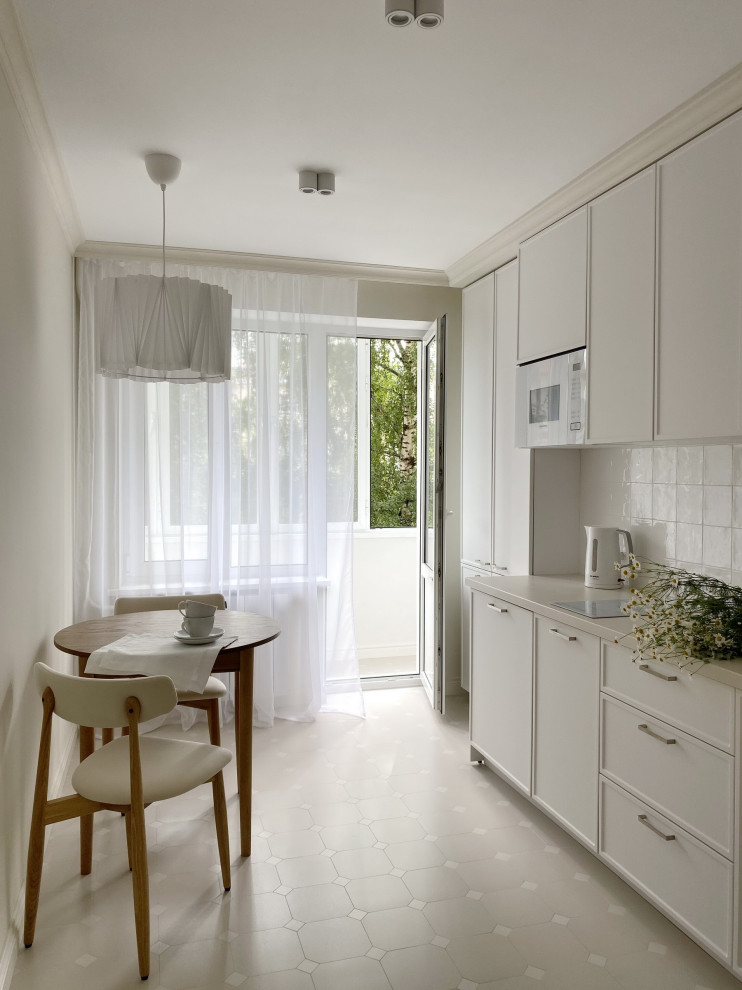 This is an example of a small single-wall separate kitchen in Moscow with a drop-in sink, beaded inset cabinets, white cabinets, laminate benchtops, white splashback, ceramic splashback, white appliances, porcelain floors, no island, beige floor and beige benchtop.