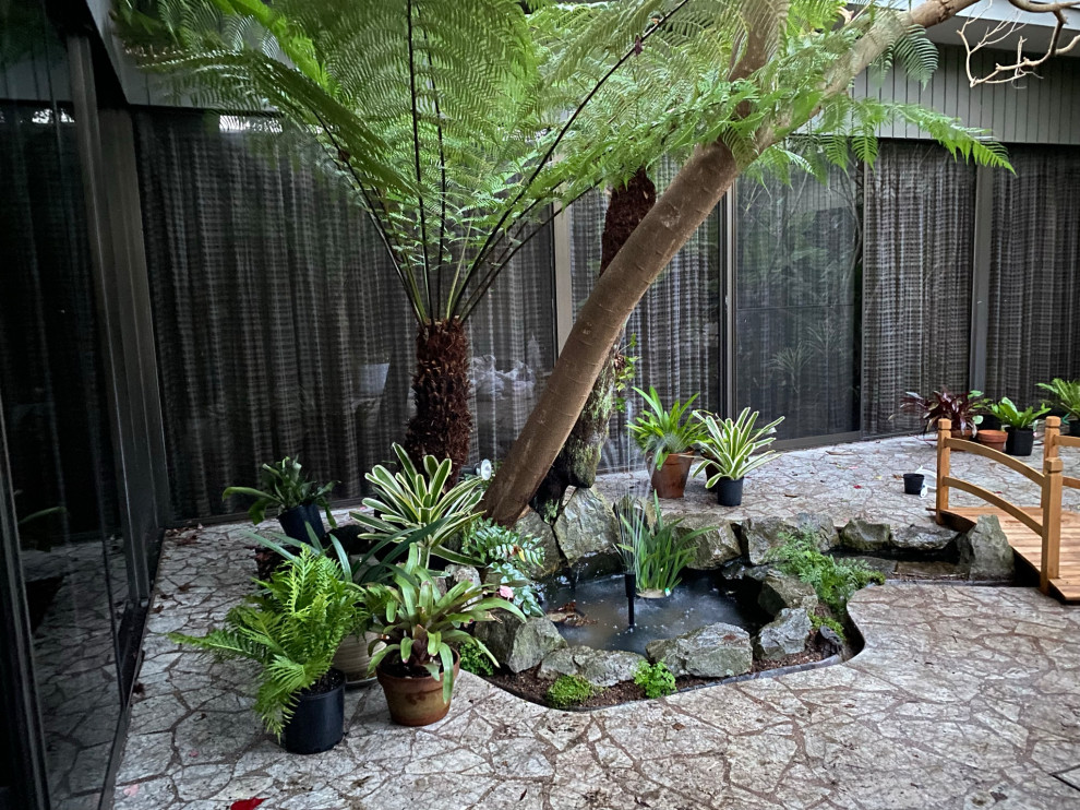 Mid-sized transitional courtyard partial sun garden in Sydney with with pond and natural stone pavers.