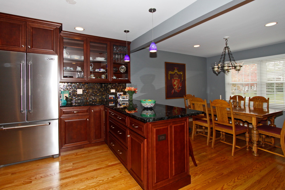 Eat-in kitchen - mid-sized transitional u-shaped medium tone wood floor eat-in kitchen idea in Chicago with an undermount sink, raised-panel cabinets, medium tone wood cabinets, granite countertops, multicolored backsplash, glass tile backsplash, stainless steel appliances and a peninsula