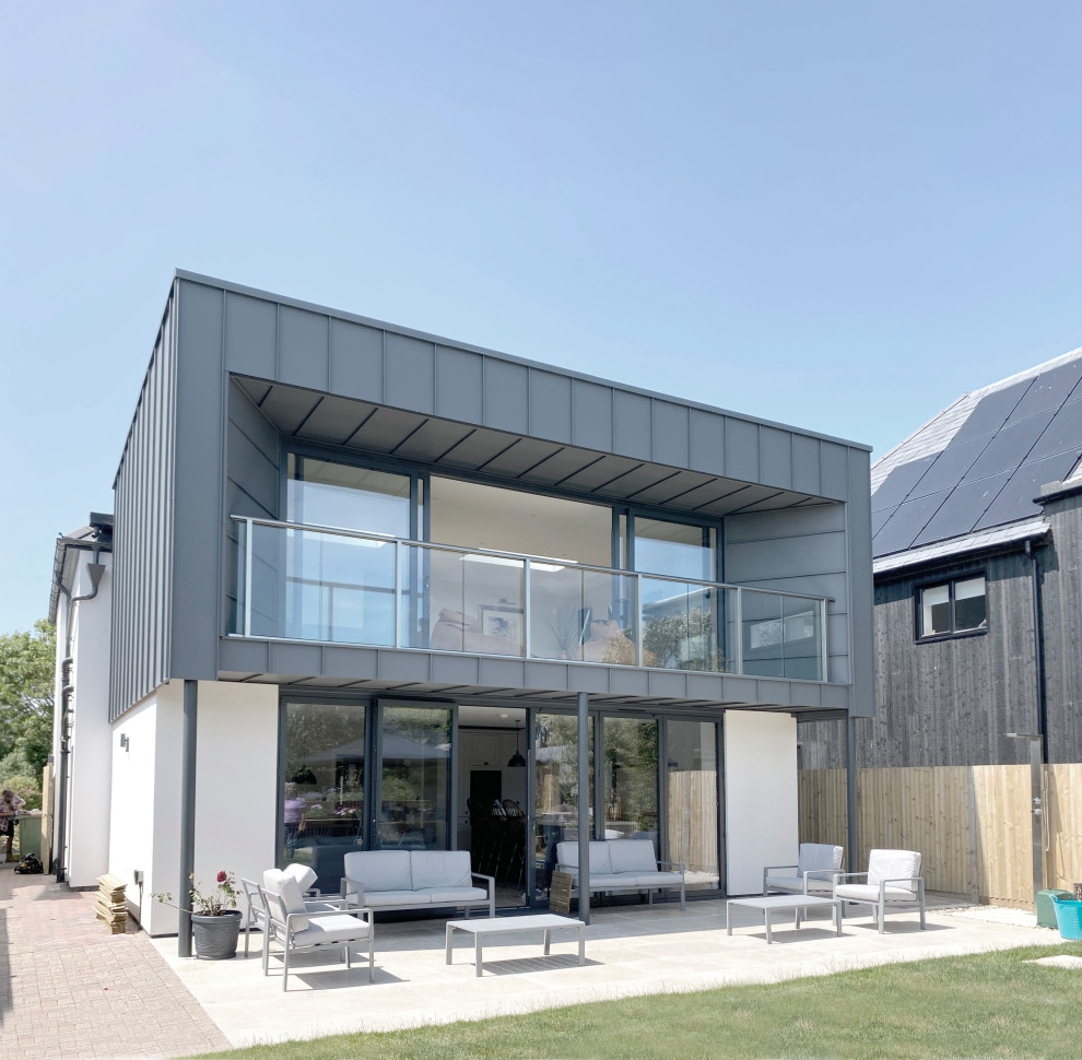 Inspiration för ett mellanstort funkis flerfärgat hus, med tre eller fler plan, metallfasad, platt tak och tak i metall