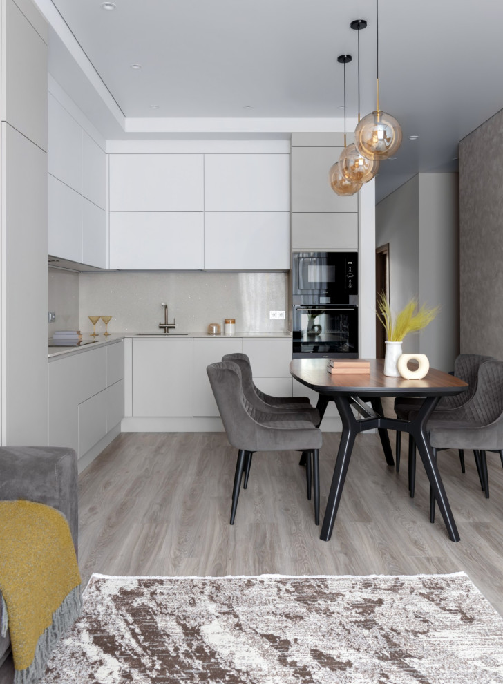 Inspiration for a medium sized contemporary grey and white l-shaped kitchen/diner in Other with a submerged sink, flat-panel cabinets, grey cabinets, engineered stone countertops, grey splashback, engineered quartz splashback, black appliances, vinyl flooring, no island, brown floors and grey worktops.