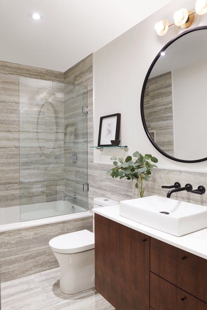 Inspiration for a mid-sized contemporary 3/4 bathroom in Toronto with flat-panel cabinets, dark wood cabinets, an alcove tub, gray tile, white walls, a vessel sink, grey floor, a shower/bathtub combo, a one-piece toilet, porcelain tile, porcelain floors, solid surface benchtops and an open shower.