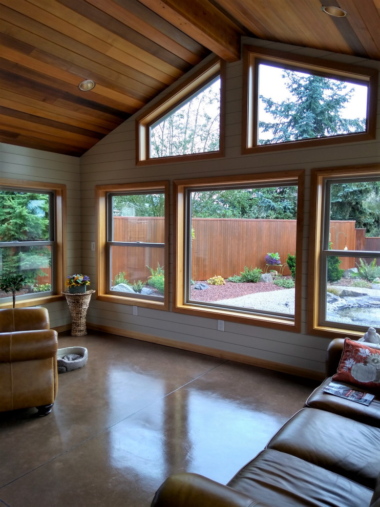 Traditional family room in Seattle with white walls, concrete floors and brown floor.